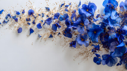Delicate blue flowers and golden seeds on white background, elegant floral arrangement with copyspace.