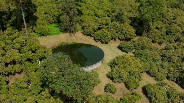 DRONE: (NOON) ORBIT SHOT OF A BIG WATER STACK AT AN AVOCADO FARM IN MICHOAC&Aacute;N