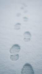 Naklejka premium Footprints trail across snowy landscape mobile wallpaper