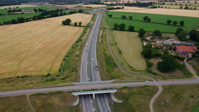 Aerial footage just outside Norwich of a dual carriageway, a road bridge and surrounds fields.
