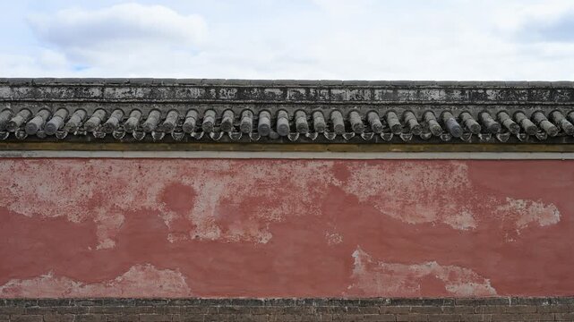 Close-up of a weathered red wall at Erdene Zuu Monastery. The peeling paint and grey roof tiles highlight the historic texture and resilience of Mongolia's oldest Buddhist site.