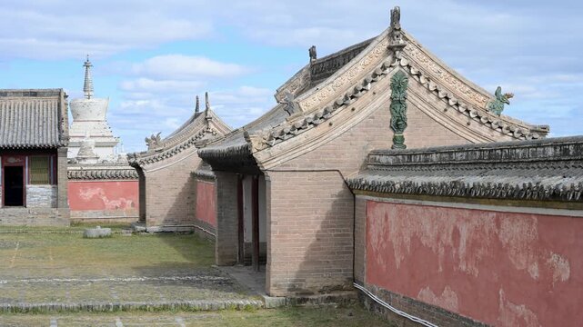 Exterior of the Laviran Temple at Erdene Zuu Monastery, Mongolia. A golden Dharma Wheel and deer adorn the green tiled roof, highlighting the 16th-century Buddhist artistry of this historic site.