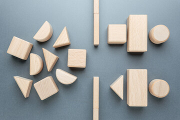Customer demand exceeding service capacity represented by wooden shapes, Wooden geometric blocks arranged to depict high customer demand on the left and limited service capacity on the right