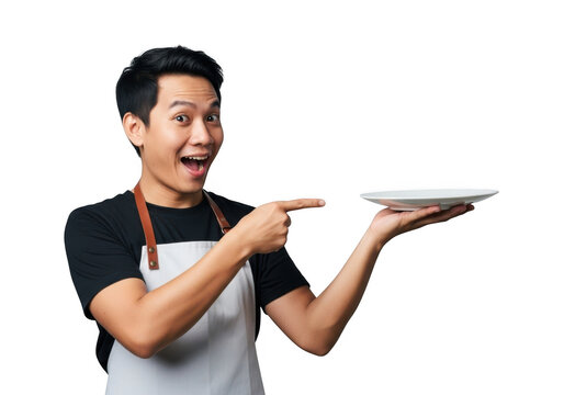 Excited asian chef holding a white plate and pointing to the side, isolated on transparent background - Powered by Adobe