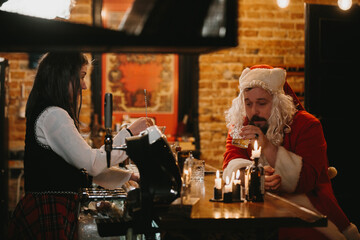 Tired santa having drink at bar