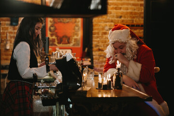 Tired santa claus sitting at bar counter