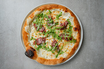 This pizza is packed with flavor, creamy cheese, fresh arugula, and tasty meat toppings