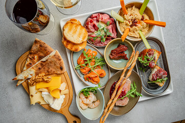 A colorful spread of tapas, cheese, and drinks invites friends to enjoy a delightful gathering