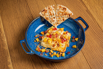 Vibrant dessert with fresh fruit and crispy flatbread, enticing on a wooden surface