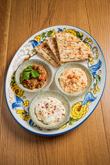 Plates filled with rich dips and warm bread create a vibrant culinary scene for sharing