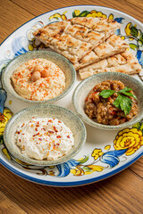 Colorful spread of Middle Eastern dips and warm pita bread ready for sharing and enjoying