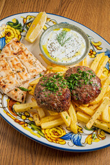 Tasty meatballs, golden fries, yogurt dip, and warm bread make a delicious meal!