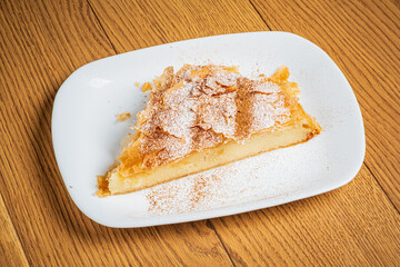 A delightful piece of pastry with a flaky crust and creamy filling, dusted with powdered sugar