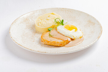 Succulent chicken breast is served alongside fluffy mashed potatoes and a perfectly cooked egg