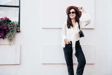 Portrait of young beautiful smiling hipster woman in trendy summer white blouse and jeans. Carefree...