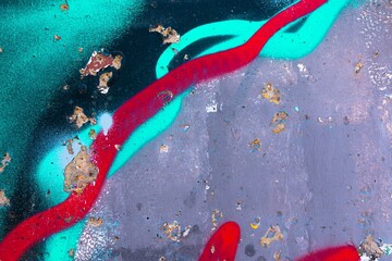 Abstract urban decay pattern with teal and red spray paint on weathered surface. Reflects 90s...