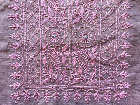 A delicate floral border, hand embroidered with fine pink threads, enhances the elegance of the pink fabric.