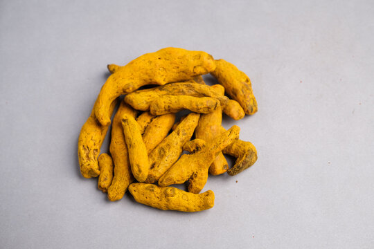Macro Close-up of Dried Yellow-Orange Turmeric Rhizome Fingers (Curcuma longa) Used as a Potent Spice, Dye, and Natural