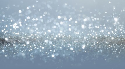 Fototapeta premium Shimmering Silver Sparkles on Soft Blue Background for Creative and Elegant Design Projects and Holiday Celebrations