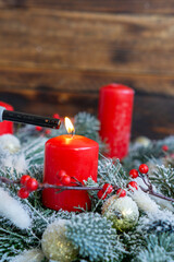 Lighting a Red Candle in Festive Winter Decor