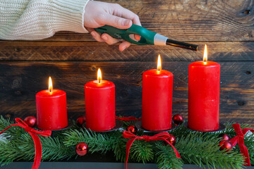 Four Red Candles Lit in a Festive Evergreen Arrangement