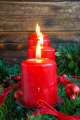 Row of Burning Red Candles with Winter Greenery