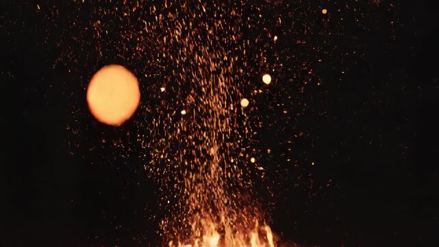 Fiery sparks and flames rising from the fire pit against a dark background creating dynamic scene