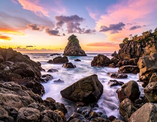 Beautiful coastal scene at sunset with large rock formations and a tranquil seascape