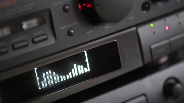 4K Hand adjusting volume knob on vintage hi-fi stereo