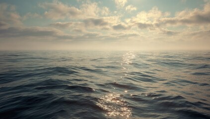 An expansive ocean scene with sunlight dancing on the water under a cloudy sky