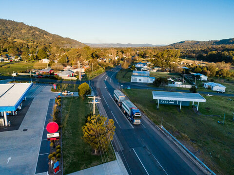 Truck travelling down highway in country town of Murrirundi seen from aerial view at sunset