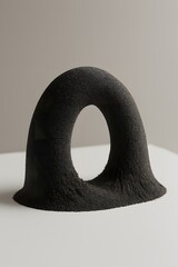 Abstract black textured sculpture with an arched opening against a minimalist background