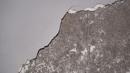 An artistic shot focusing on the rough, black, broken edge of the wall coating, suitable for abstract or conceptual design. © Andik