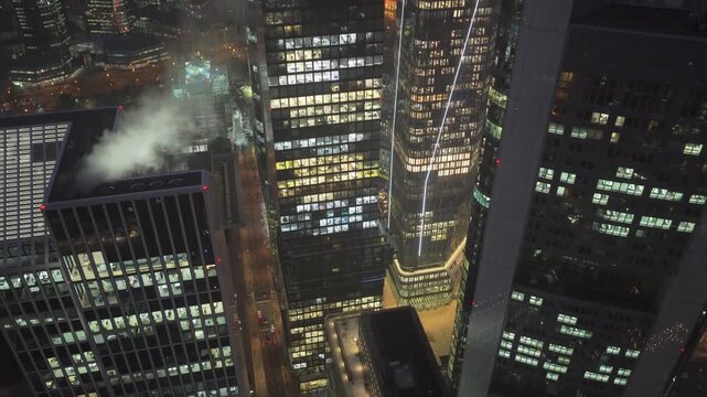 Tripod aerial view of Frankfurt's bustling financial district including Omniturm. Illuminated skyscrapers and modern towers define the cityscape at night