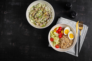 Healthy breakfast. Bowl of oatmeal, fresh vegetables, boiled egg and avocado salad. Top view.