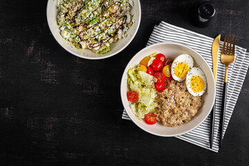 Healthy breakfast. Bowl of oatmeal, fresh vegetables, boiled egg and avocado salad. Top view.