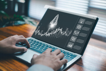 Hands typing on a laptop launching a digital rocket startup with global technology icons, symbolizing innovation, growth, strategy, data analytics, and modern entrepreneurship.
