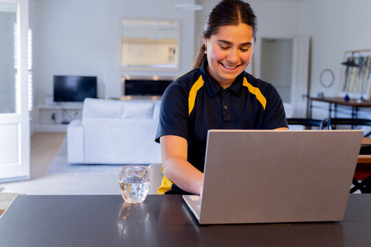Tween girl doing homework using a laptop