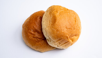 Close-up view of two light, fluffy bread rolls with a shiny, perfectly baked crust, ideal for breakfast, dinner, or dessert applications.