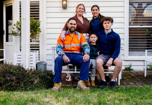 Portrait of mixed ethnicity family in front of white house