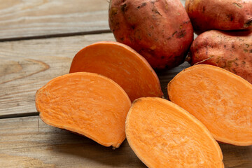 d halved raw sweet potatoes on rustic wooden boards. 