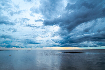 Dramatic Storm Clouds Over Expansive Water at Sunset