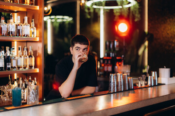 Young Man Enjoying a Drink at Stylish Modern Bar Interior