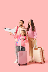 Family of travelers with suitcases and paper airplane on pink background