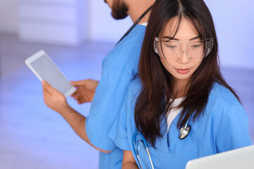 Female Asian doctor analyzing scientific data in laboratory