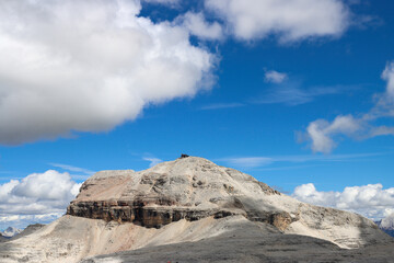 Alpine panorama from Rifugio Maria at Passo Pordoi, with Piz Boè rising under drifting white clouds