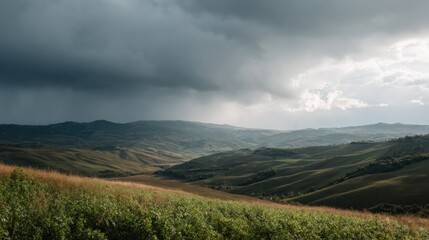 Landscape photograph of a vast open field with rolling hills and valleys. the sky is filled with dark, ominous clouds that are covering most of the sky.