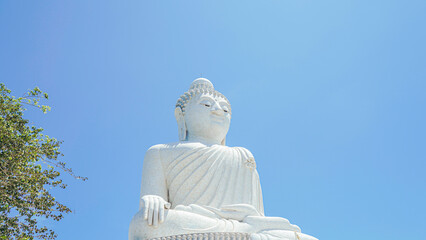 Phuket Big Buddha statue. afternoon light sky and blue ocean are on the back of white Phuket big Buddha is the one of landmarks on Phuket island Thailand.
