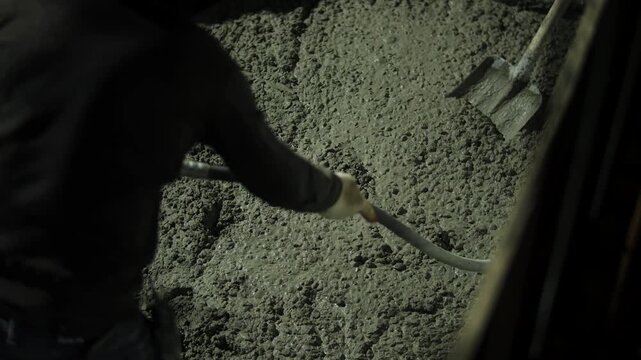 Vibrating fresh concrete during compaction at construction site
