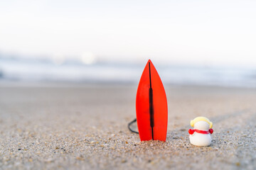Sandy Christmas Snowman is watching the waves, standing on beautiful beach with a surf board - horizontal version in Patong Beach, Phuket, Thailand